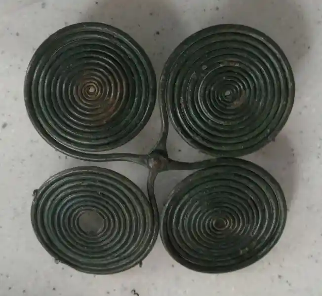 Fibula of four intersecting spirals forming a cross